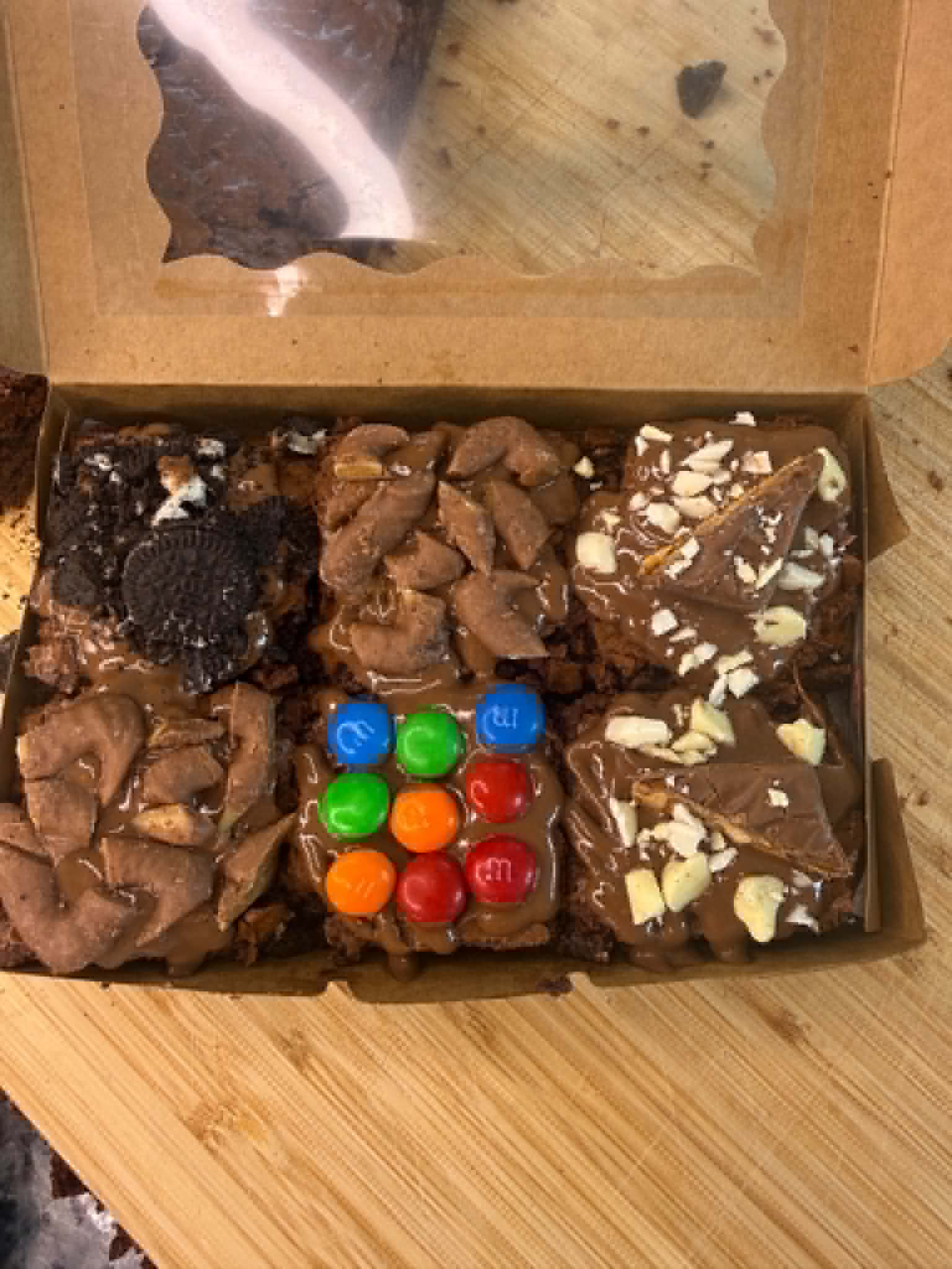 Chocolate brownie tray cut into squares and topped with malteser, m&m, Oreo and biscoff